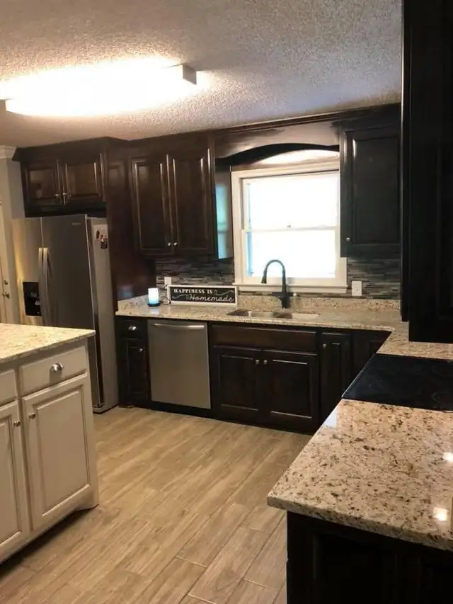 Dark espresso kitchen cabinets with light granite countertops, a glass tile backsplash and a window over the sink